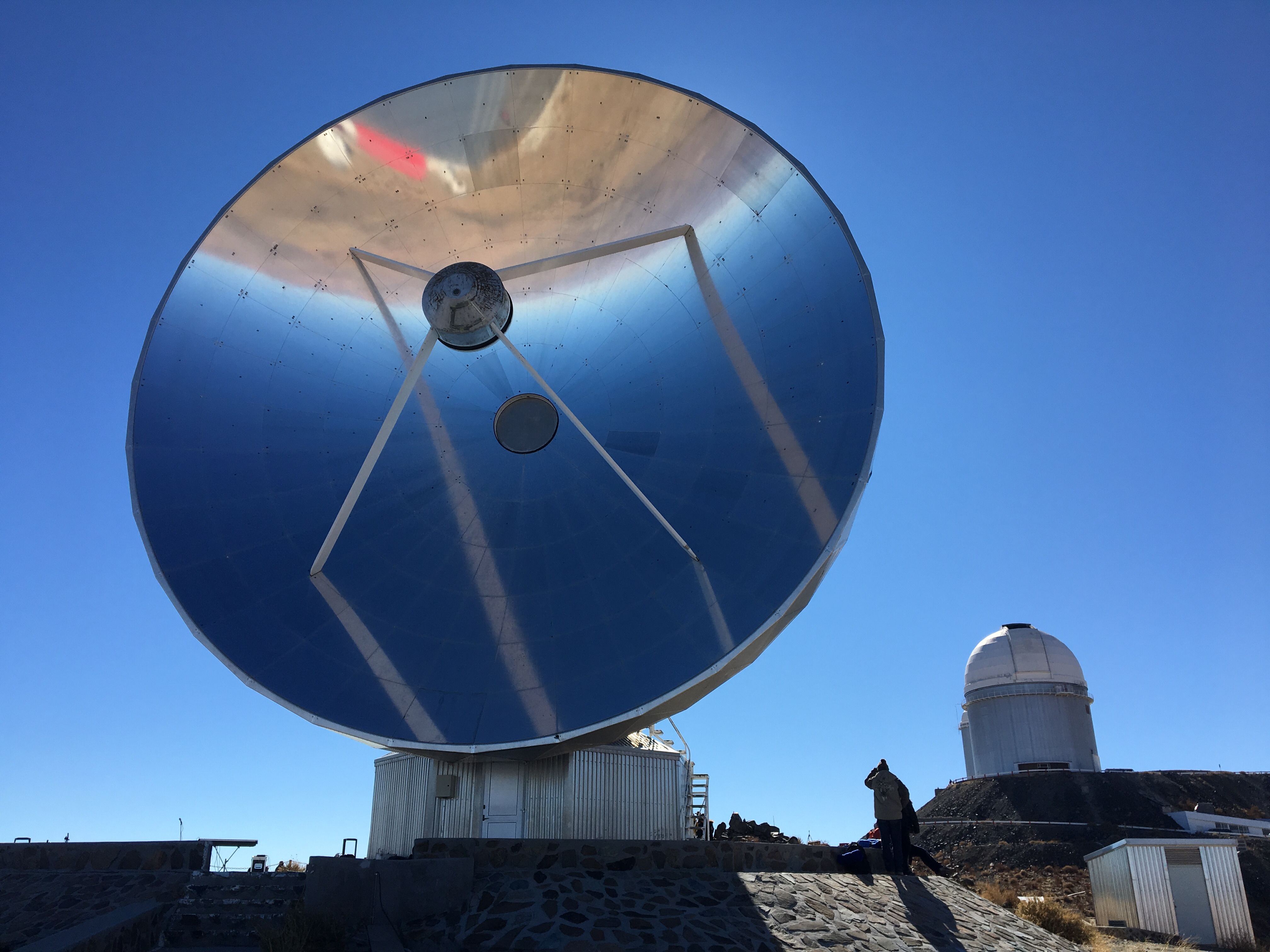 A mirrored dish and telescope dome at La Silla observatory, Chile.